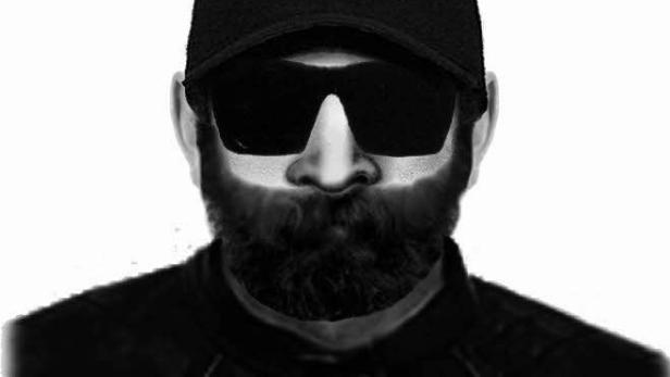 Ein Mann mit Bart, Sonnenbrille und Kappe in Schwarzweiß.
