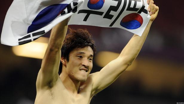 Ein Mann hält eine koreanische Flagge mit der Aufschrift „Wir sind die Besten“ hoch.