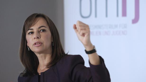 Eine Frau gestikuliert vor einem Banner des Bundesministeriums für Familie, Senioren, Frauen und Jugend.