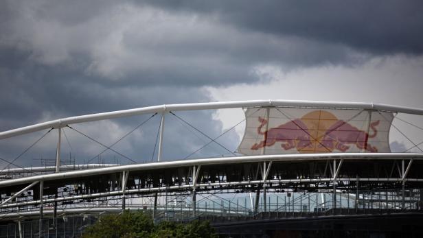 Das Red Bull Logo auf dem Dach eines Stadions vor dunklen Wolken.