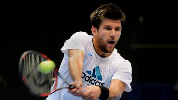 Ein Tennisspieler schlägt einen Ball mit seinem Schläger.