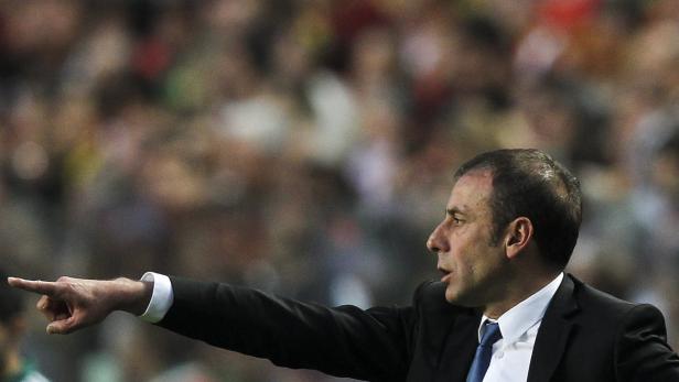 Ein Mann in einem Anzug zeigt mit dem Finger in eine Richtung.