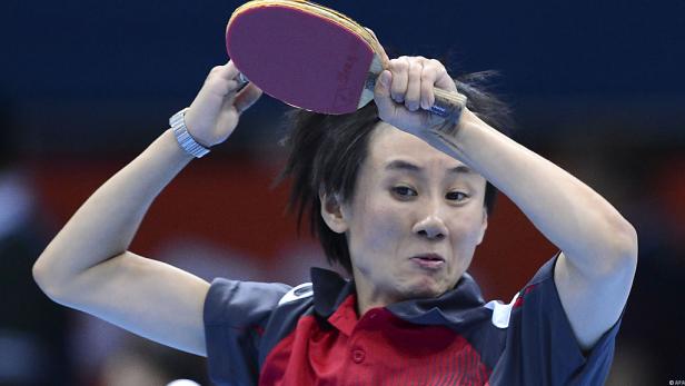 Eine Tischtennisspielerin beim Aufschlag.