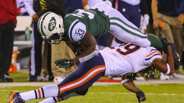Ein Footballspieler der New York Jets wird von einem Spieler der Chicago Bears getackelt.