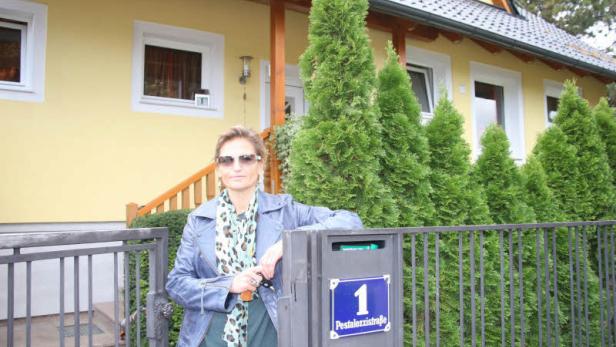 Eine Frau steht vor einem gelben Haus an der Pestalozzistraße 1.