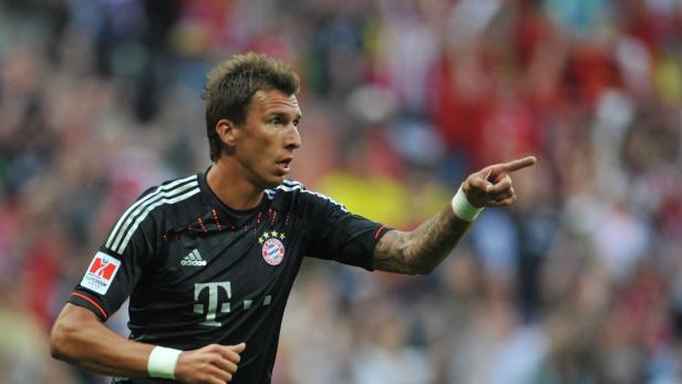 Ein Fußballspieler des FC Bayern München zeigt mit dem Finger nach rechts.