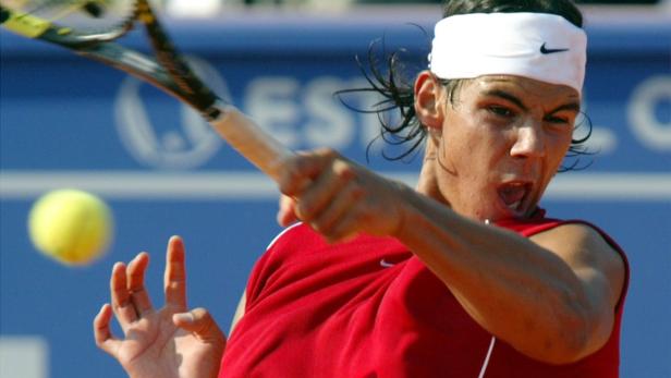 Rafael Nadal schlägt einen Tennisball während eines Spiels.