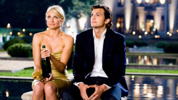 Cameron Diaz und Ashton Kutcher sitzen mit einer Champagnerflasche am Pool.