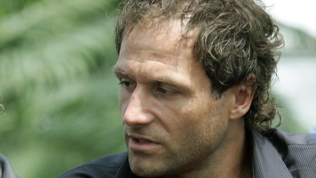 Nahaufnahme eines Mannes mit lockigem Haar und einem Hemd.