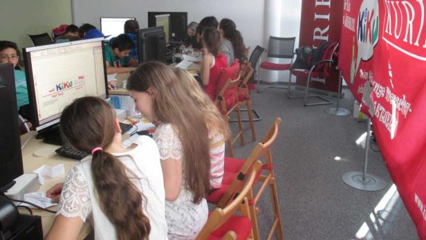 Eine Gruppe von Kindern arbeitet an Computern in einem Klassenzimmer.