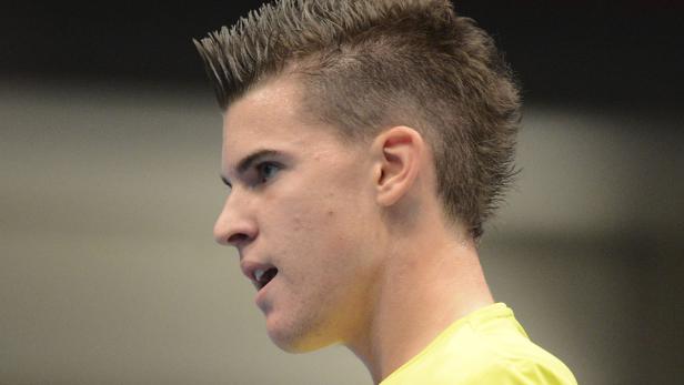 Ein junger Mann mit einem Irokesenschnitt schaut zur Seite.