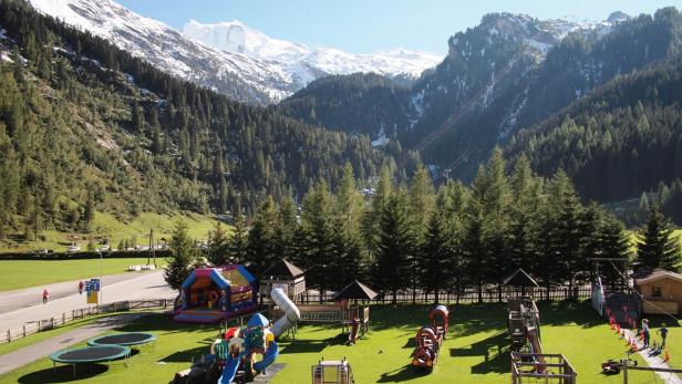 Ein Spielplatz in den Bergen mit Trampolinen, Rutschen und anderen Spielgeräten.