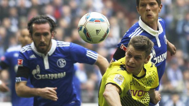 dapdDortmunds Lukasz Piszczek of Poland, right, and Schalkes Christian Fuchs of Austria, left, and Schalkes Klaas-Jan Huntelaar of the Netherlands, rear, challenge for the ball during the German first division Bundesliga soccer match between Schalke 04 an Fuchs im Revierderby-Fieber