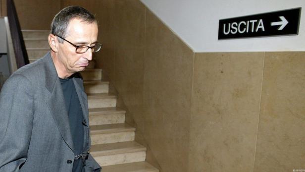 Ein Mann mit Brille geht eine Treppe hinunter, neben einem Ausgangsschild.