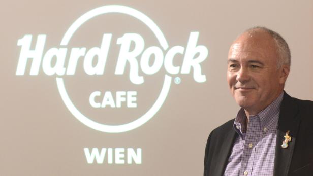 Ein Mann steht vor einer Projektion des Hard Rock Cafe Wien Logos.