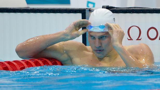 Ein Schwimmer mit Badekappe und Schwimmbrille im Schwimmbecken.