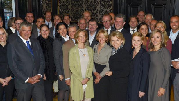 Eine Gruppe von Männern und Frauen posiert für ein Gruppenfoto.