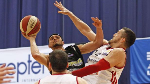 Zwei Basketballspieler kämpfen um den Ball während eines Spiels.