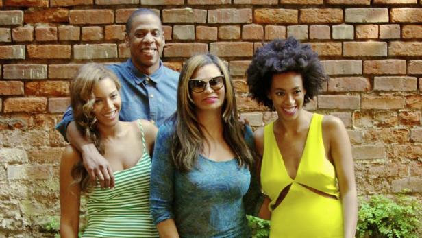 Beyoncé, Jay-Z, Tina Knowles und Solange Knowles posieren vor einer Ziegelwand.
