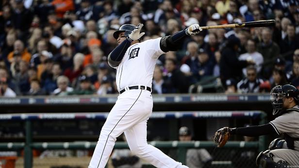 Ein Baseballspieler schlägt den Ball vor einer Zuschauermenge.