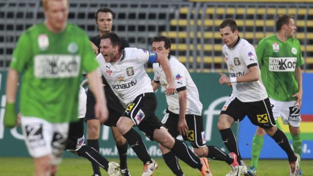 Fußballspieler rennen während eines Spiels auf dem Rasen.