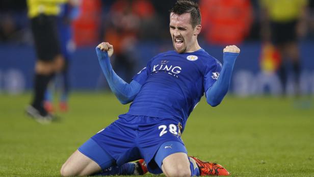 Ein Fußballspieler in blauer Uniform jubelt auf dem Rasen.