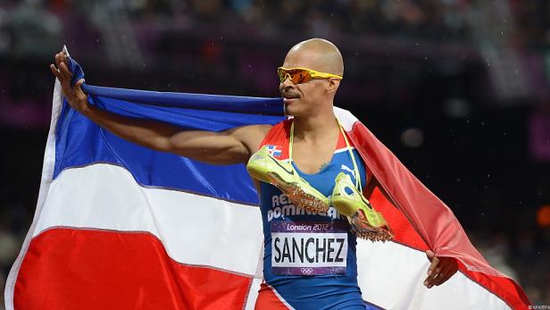 Félix Sánchez, gehüllt in die Flagge der Dominikanischen Republik, feiert seinen Sieg.