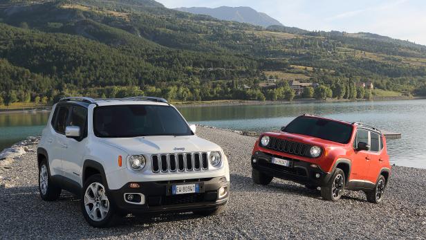 Zwei Jeep Renegade, ein weißer und ein roter, stehen an einem Seeufer.