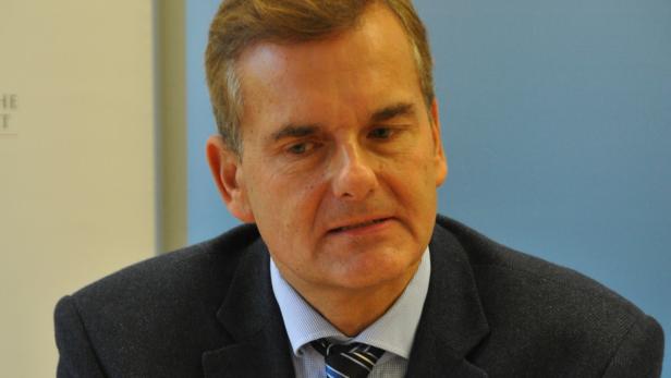 Ein Mann mit Anzug und Krawatte blickt in die Ferne.