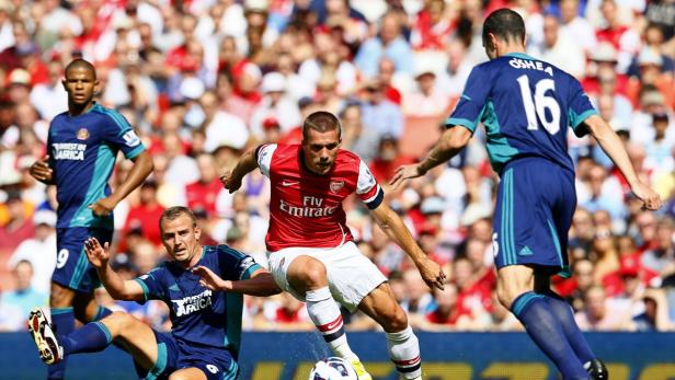 Ein Fußballspieler von Arsenal dribbelt den Ball während eines Spiels.