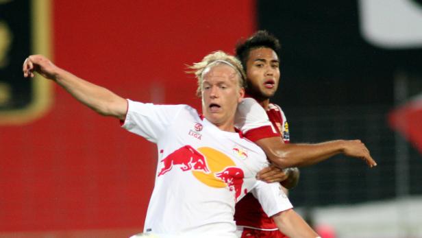 Zwei Fußballspieler kämpfen um den Ball während eines Spiels.