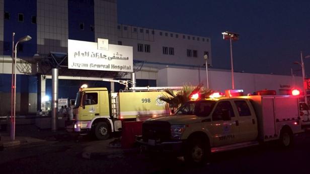 Mehrere gelbe Feuerwehrfahrzeuge stehen vor dem Jazan General Hospital.