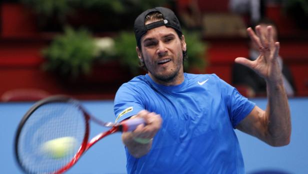 Ein Tennisspieler schlägt einen Ball mit seinem Schläger.