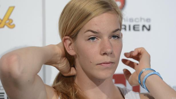 Porträt einer jungen Frau mit blonden Haaren und blauen Augen.