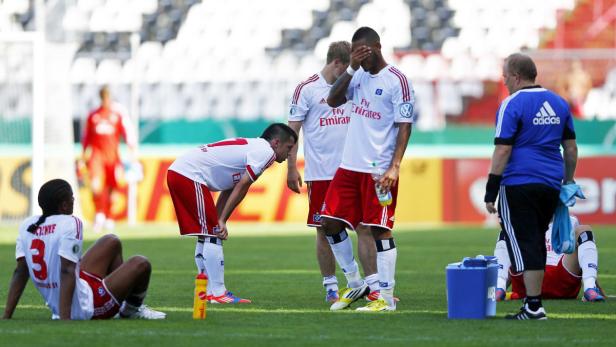 Enttäuschte Fußballspieler des Hamburger SV auf dem Rasen.
