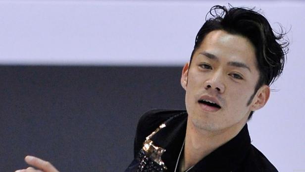 Nahaufnahme eines japanischen Eiskunstläufers in einem glitzernden Kostüm.