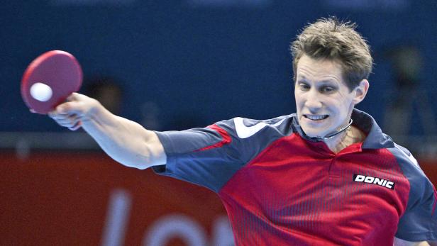 Ein Tischtennisspieler schlägt den Ball mit seinem Schläger.