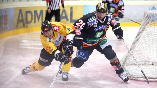 Zwei Eishockeyspieler kämpfen auf dem Eis um den Puck.