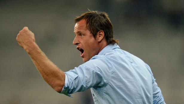 Ein Mann in einem hellblauen Hemd ballt die Faust und schreit.