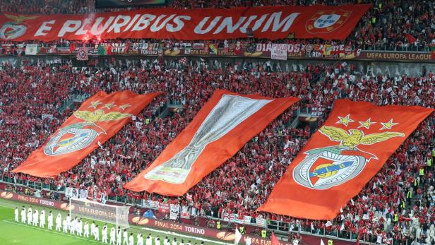 Fußballfans schwenken große Banner mit dem Benfica-Logo und dem Schriftzug „E Pluribus Unum“.