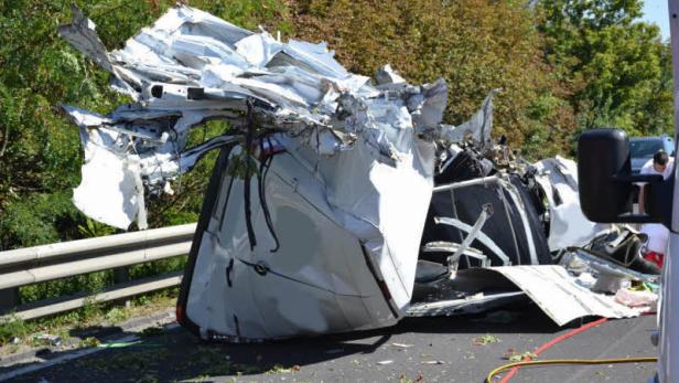 Ein völlig zerstörter Lieferwagen liegt auf einer Straße.