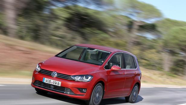 Ein roter VW Golf fährt auf einer Landstraße.