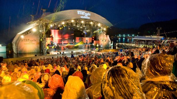 Publikum bei der „StarNacht am Wörthersee“ mit Bühne und Musikern im Hintergrund.