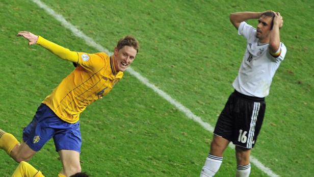 Ein schwedischer Fußballspieler jubelt, während ein deutscher Spieler enttäuscht ist.