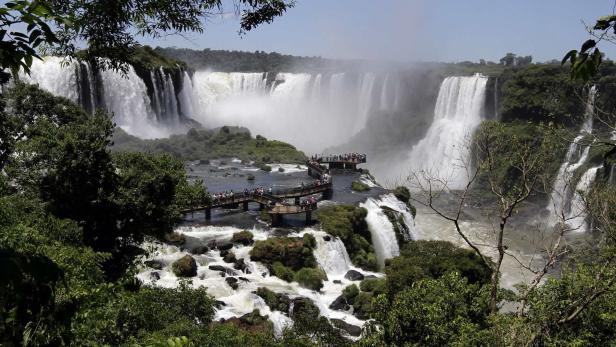 Die beeindruckenden Iguazú-Wasserfälle mit Besuchern auf Stegen.