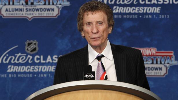 Ein Mann steht vor einem Banner der NHL Winter Classic.