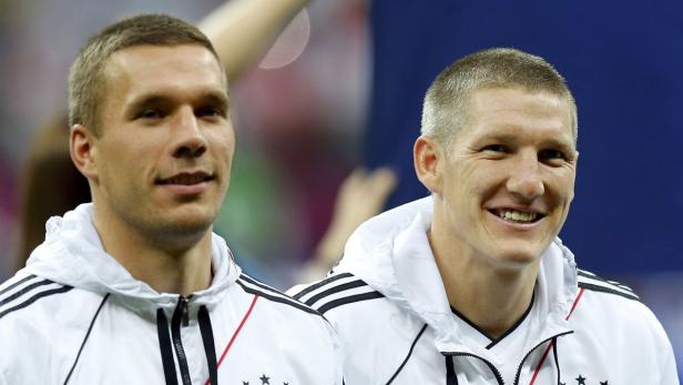 Germany&#039;s Lukas Podolski and Bastian Schweinsteiger (R) smile before the Euro 2012 semi-final soccer match between Germany and Italy at the National stadium in Warsaw, June 28, 2012. REUTERS/Thomas Bohlen (POLAND - Tags: SPORT SOCCER)