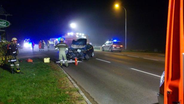 Ein schwerer Autounfall auf einer dunklen Straße mit Rettungskräften vor Ort.