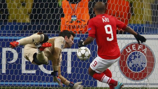 Ein Fußballspieler namens Ari schießt auf das Tor, während der Torwart versucht, den Ball abzuwehren.