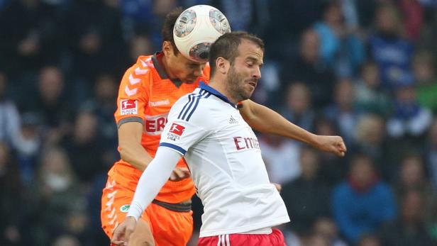 Zwei Fußballspieler kämpfen um den Ball mit ihren Köpfen.